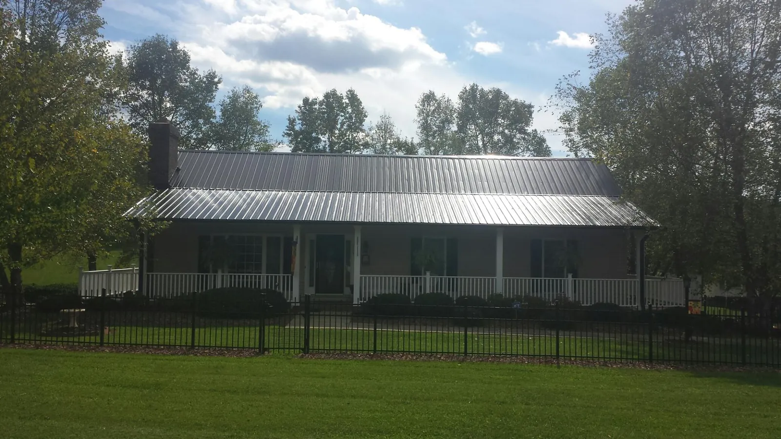 Gray metal roof on a brick ranch with a full width front porch — Gutter Guard Installation work by our crew in Detroit