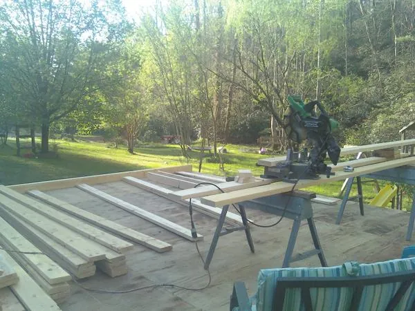 Miter saw and framing lumber on a deck under construction in Detroit